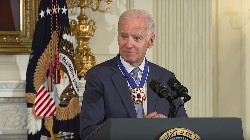Joe Biden speaks at a podium after receiving the Presidential Medal of Freedom.